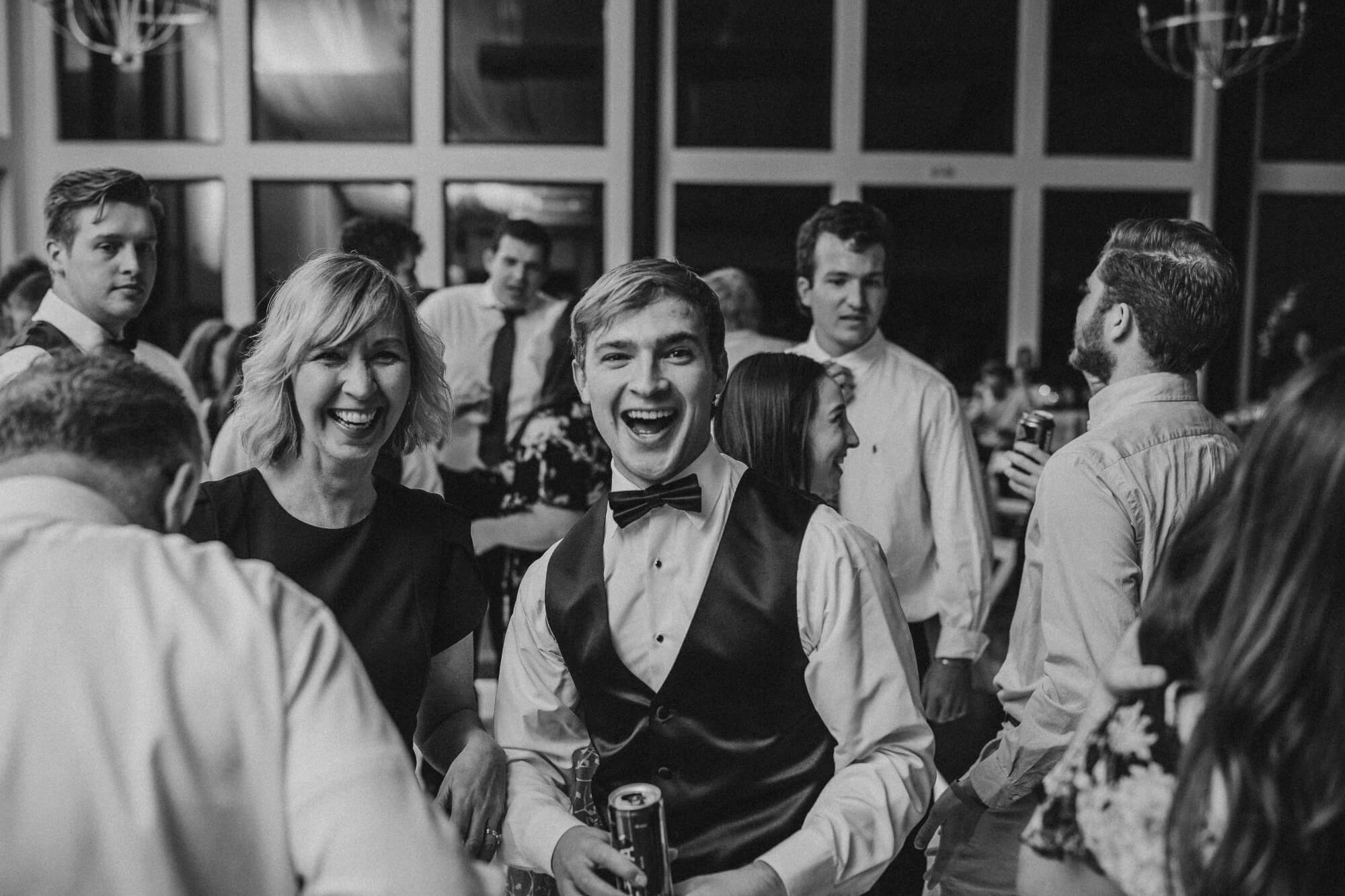 Young man and mom laughing on wedding dance floor