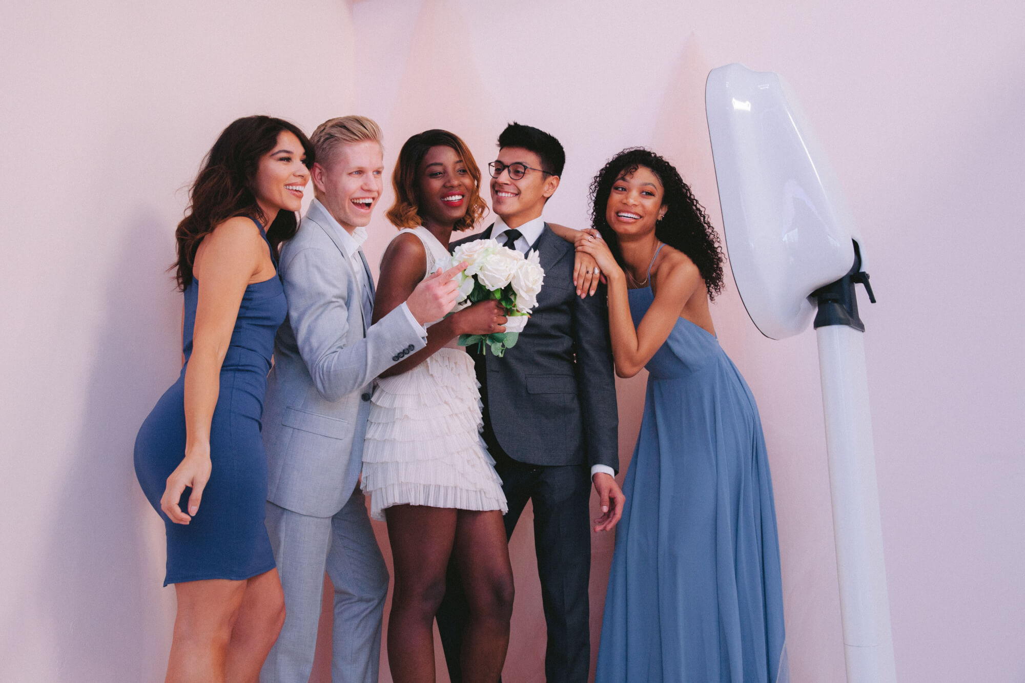 Bride, groom, groomsman and bridesmaids posing in front of Ozark Pix photo booth